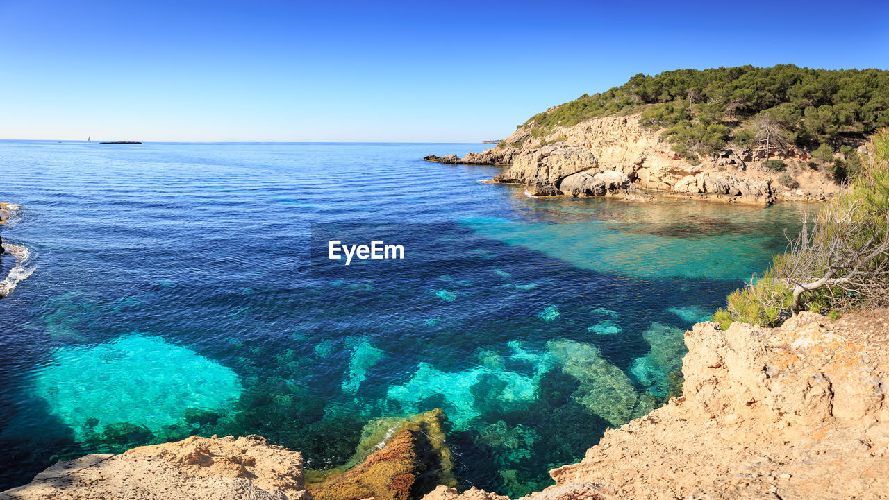 Scenic view of sea against clear blue sky