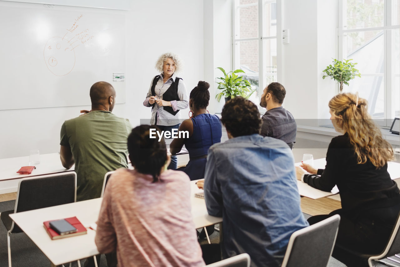 High angle view of students listening to teachers at language class