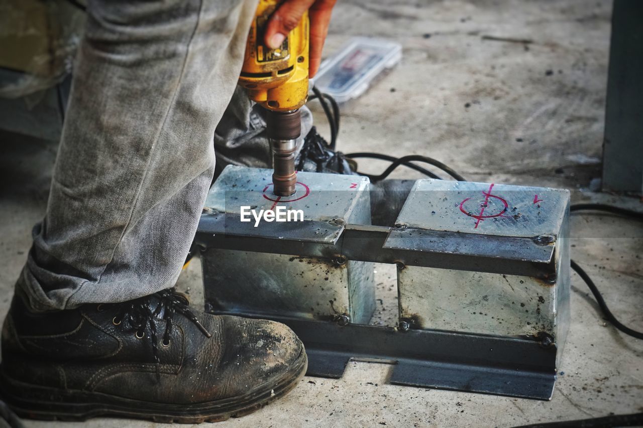 Low section of manual worker working on construction site