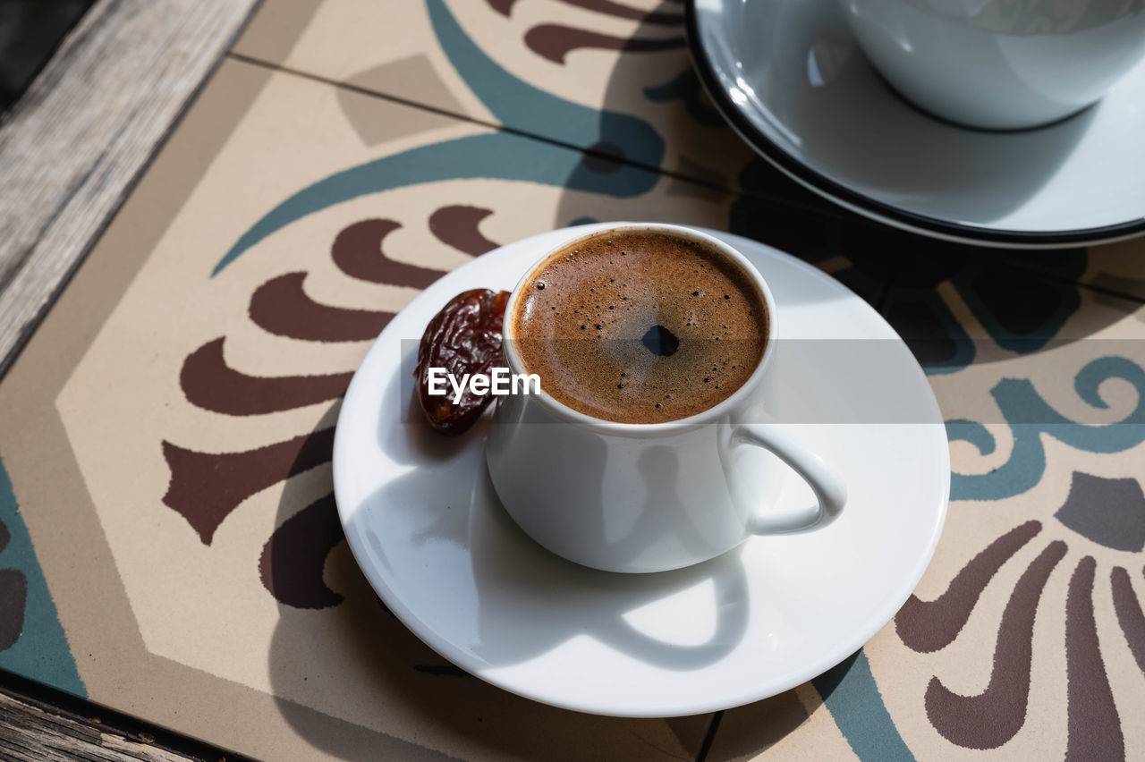 HIGH ANGLE VIEW OF COFFEE CUP ON TABLE WITH TEA