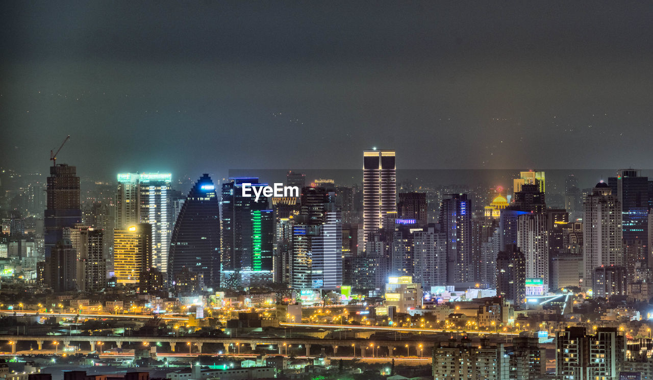 Illuminated cityscape against sky at night