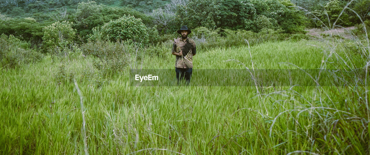 Portrait of man standing amidst plants