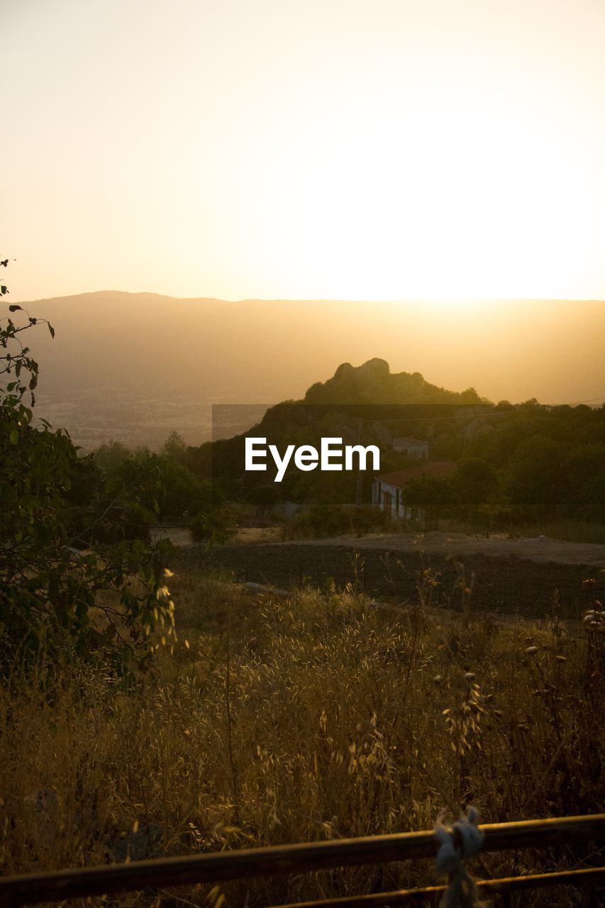 SCENIC VIEW OF FIELD AND MOUNTAINS AGAINST CLEAR SKY