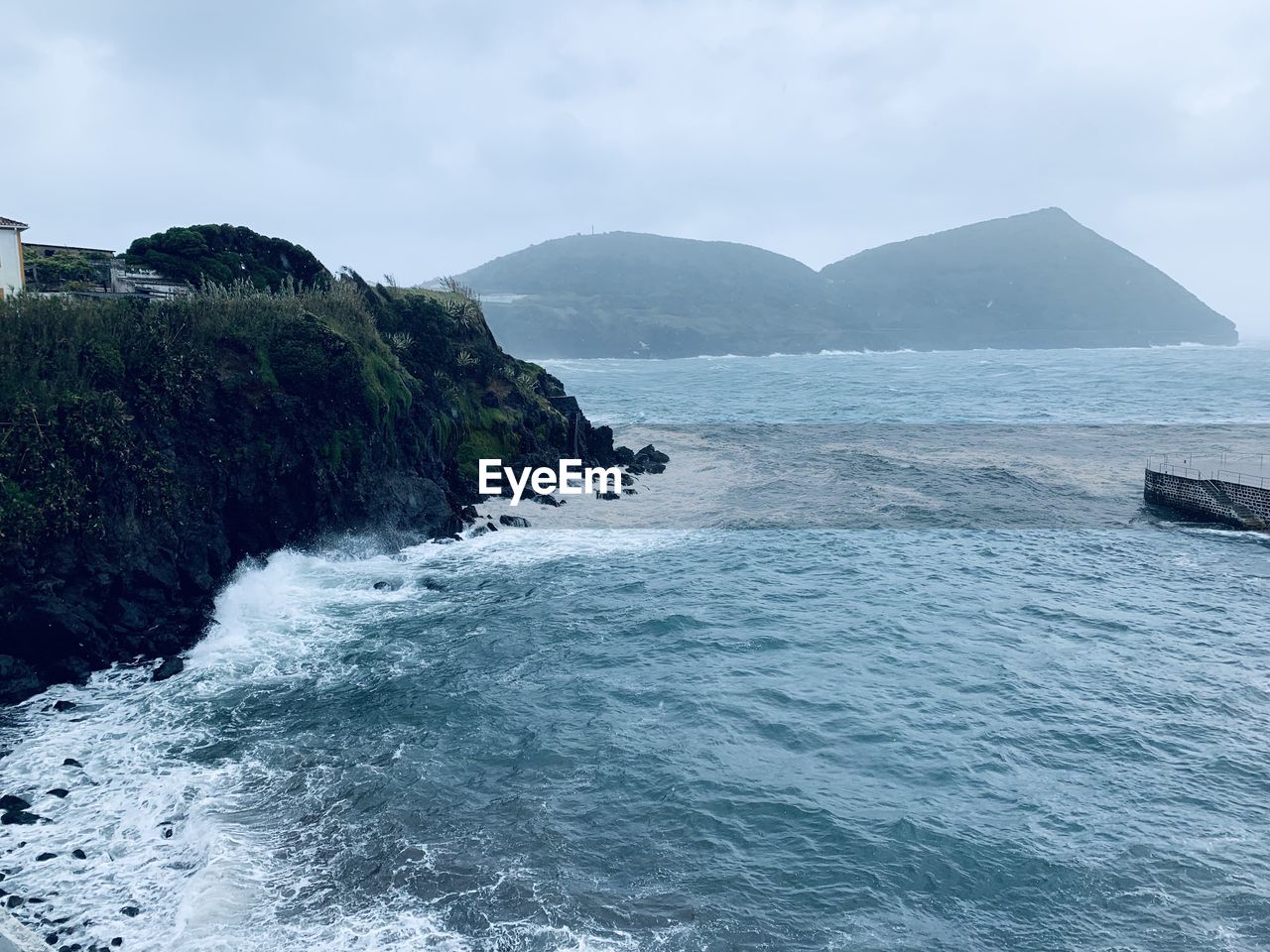 SCENIC VIEW OF SEA BY MOUNTAINS AGAINST SKY