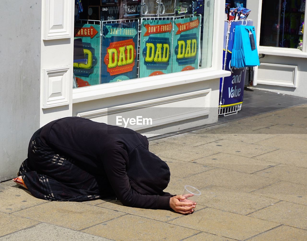 Woman begging on sidewalk