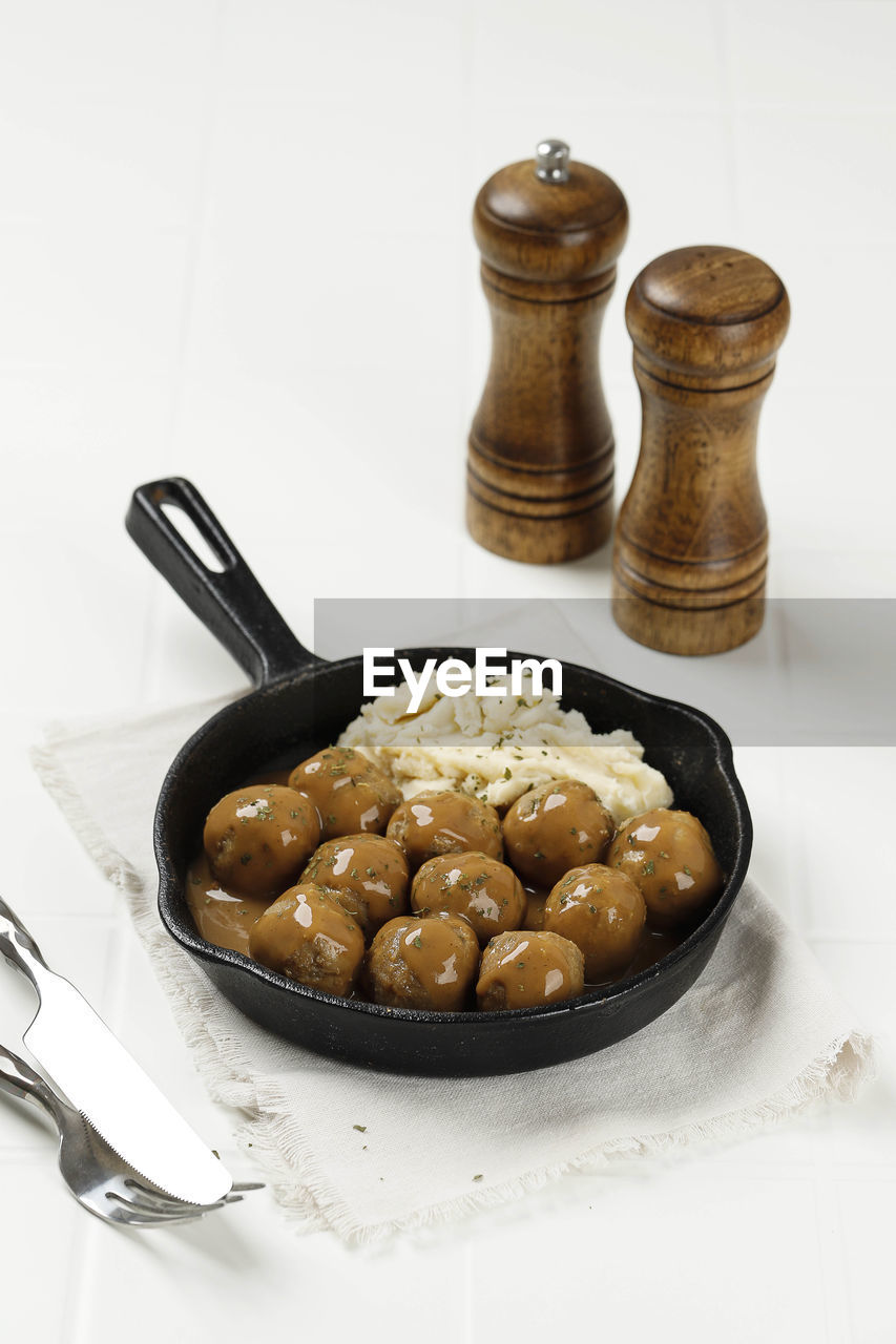 Greek meatballs or keftedes with mashed potato on white table background