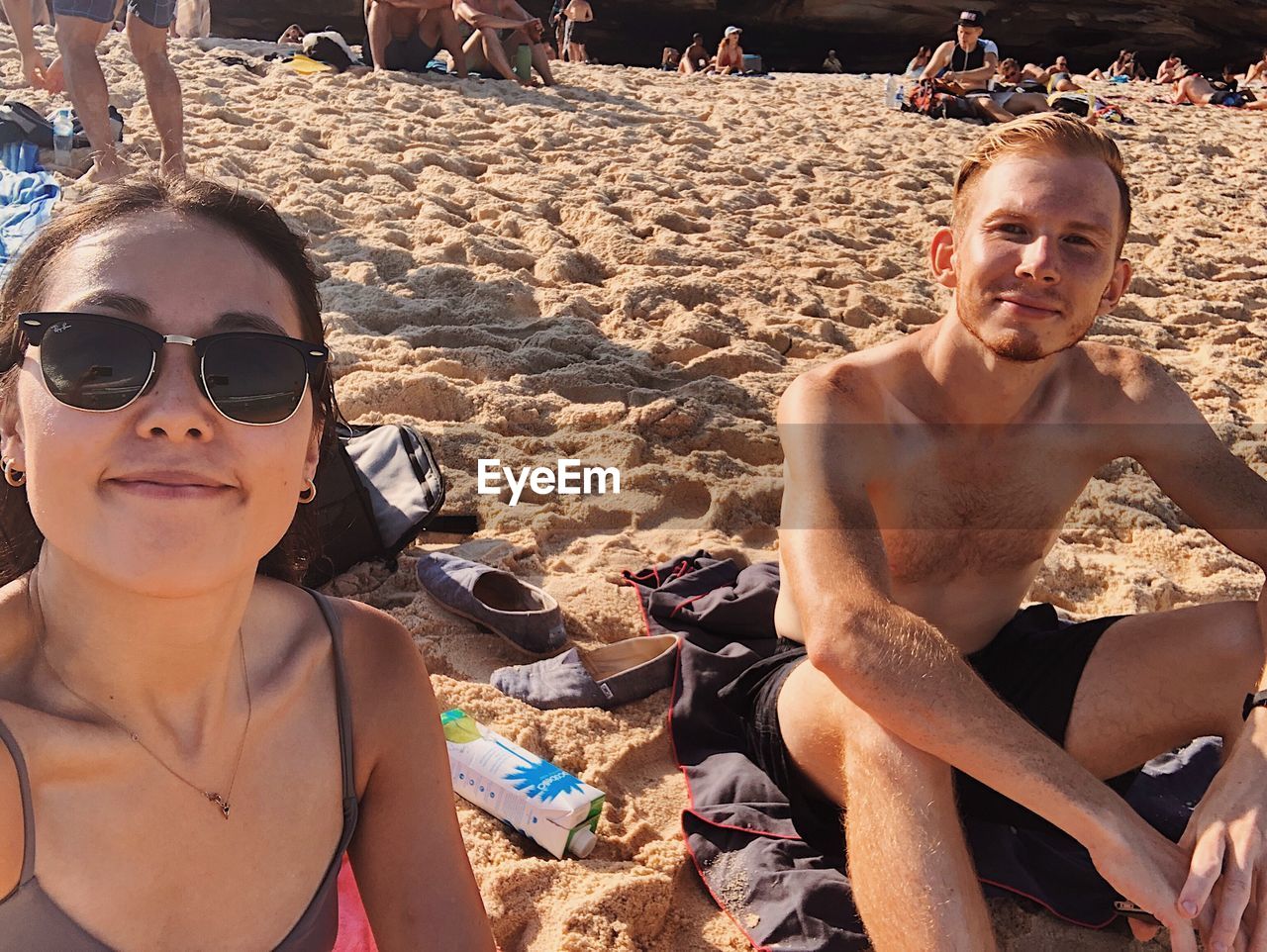 PORTRAIT OF HANDSOME YOUNG MAN WEARING SUNGLASSES ON BEACH