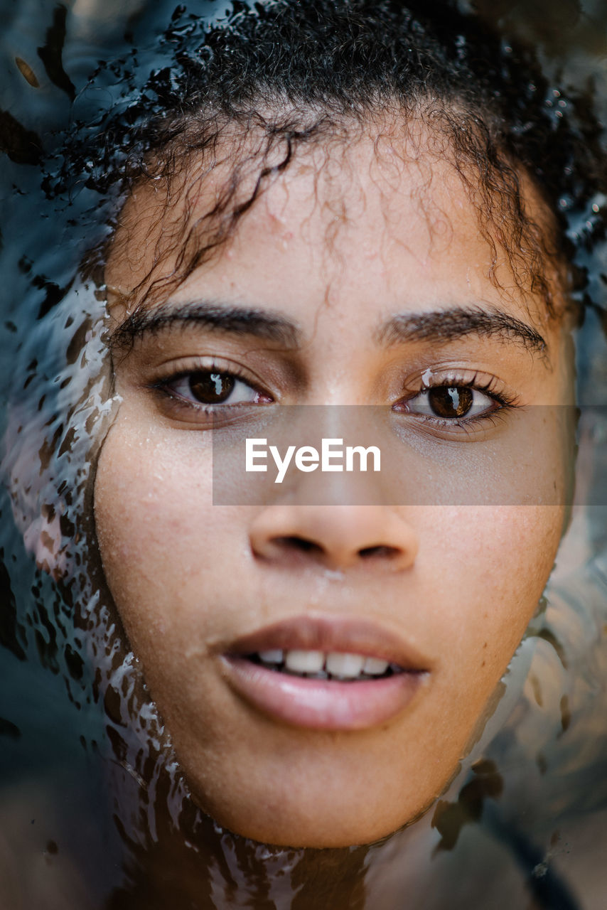 Close-up portrait of young woman in sea