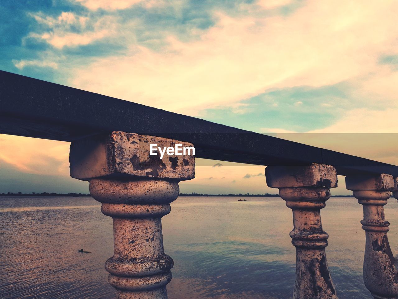 METALLIC BRIDGE OVER SEA AGAINST SKY