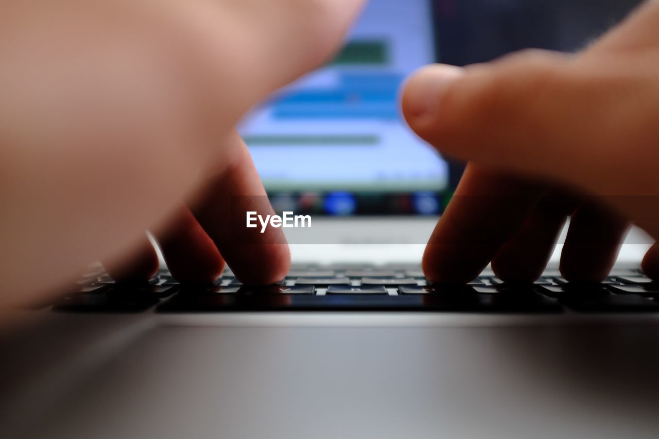 Close-up of man using laptop