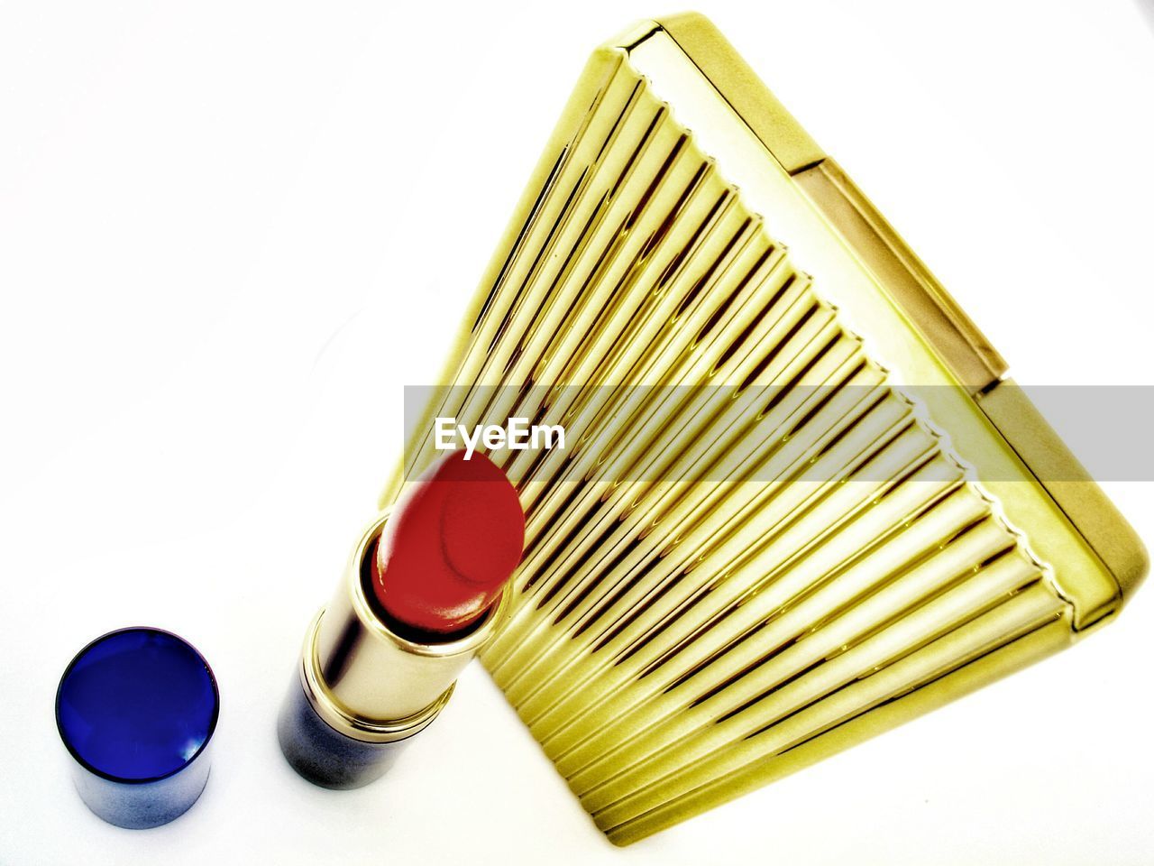 High angle view of lipstick and purse against white background