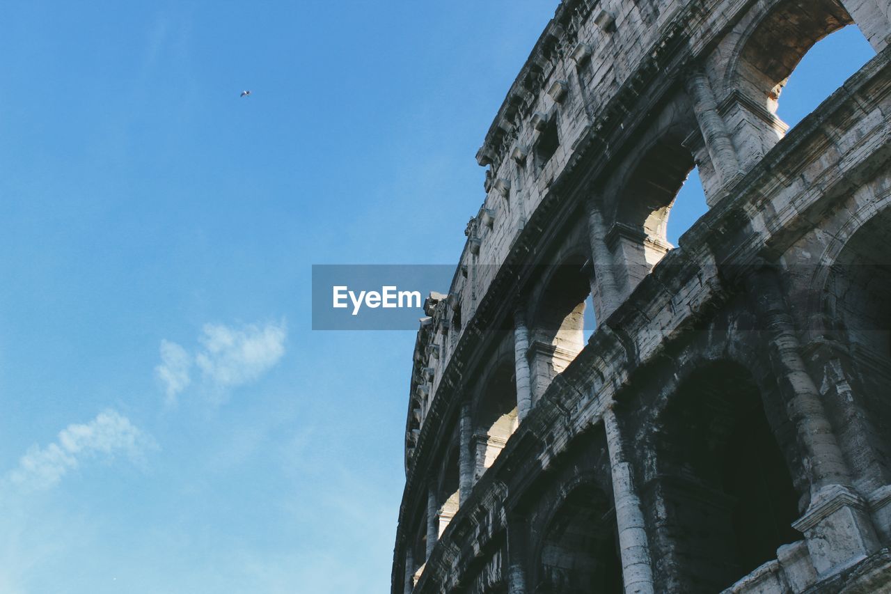 Low angle view of colosseum against sky in city