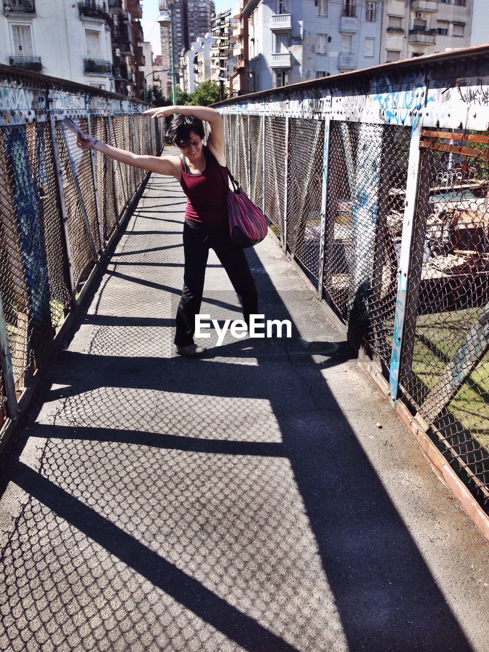 YOUNG WOMAN STANDING IN PARK