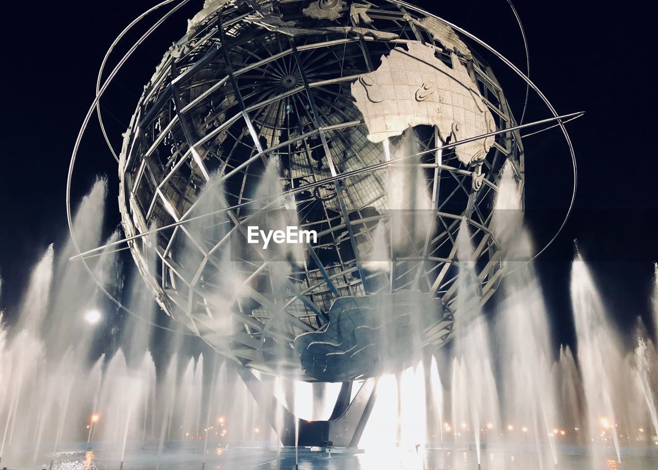 LOW ANGLE VIEW OF ILLUMINATED FOUNTAIN AGAINST SKY