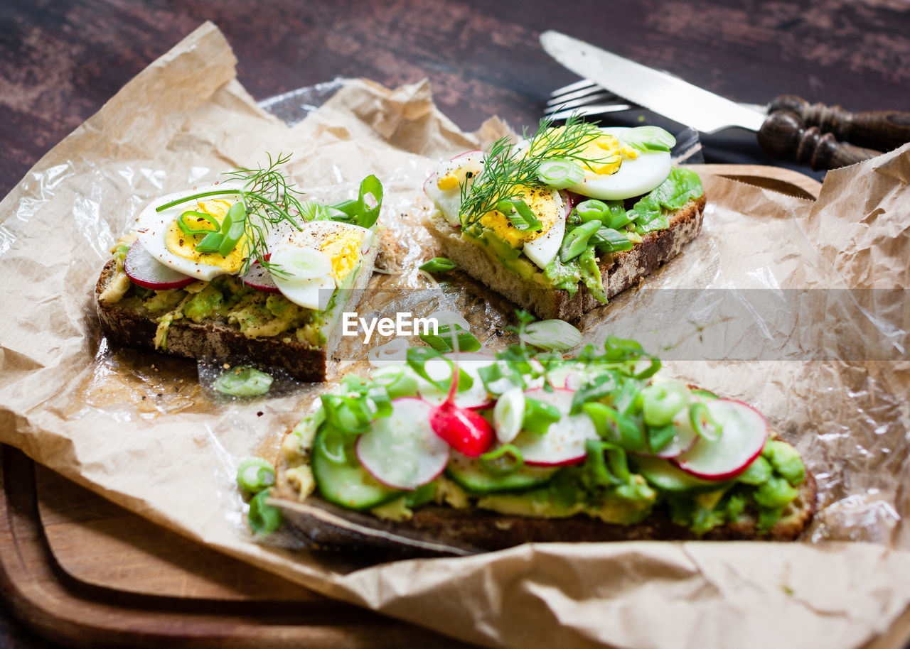 High angle view of open faced sandwiches on wax paper