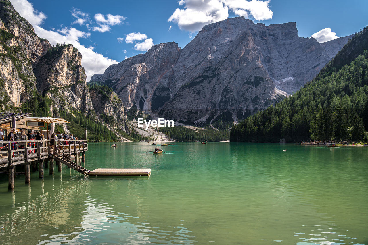 mountain, water, scenics - nature, mountain range, beauty in nature, lake, sky, nature, landscape, environment, tree, travel destinations, land, tranquility, tranquil scene, reflection, plant, travel, forest, mountain peak, nautical vessel, cloud, pine tree, no people, tourism, idyllic, coniferous tree, pinaceae, architecture, pine woodland, non-urban scene, snow, activity, blue, rock, outdoors, day, vacation, waterfront, trip, rocky mountains, holiday, transportation, cold temperature, leisure activity, built structure, formation, turquoise colored, wilderness, snowcapped mountain, summer, building, beach