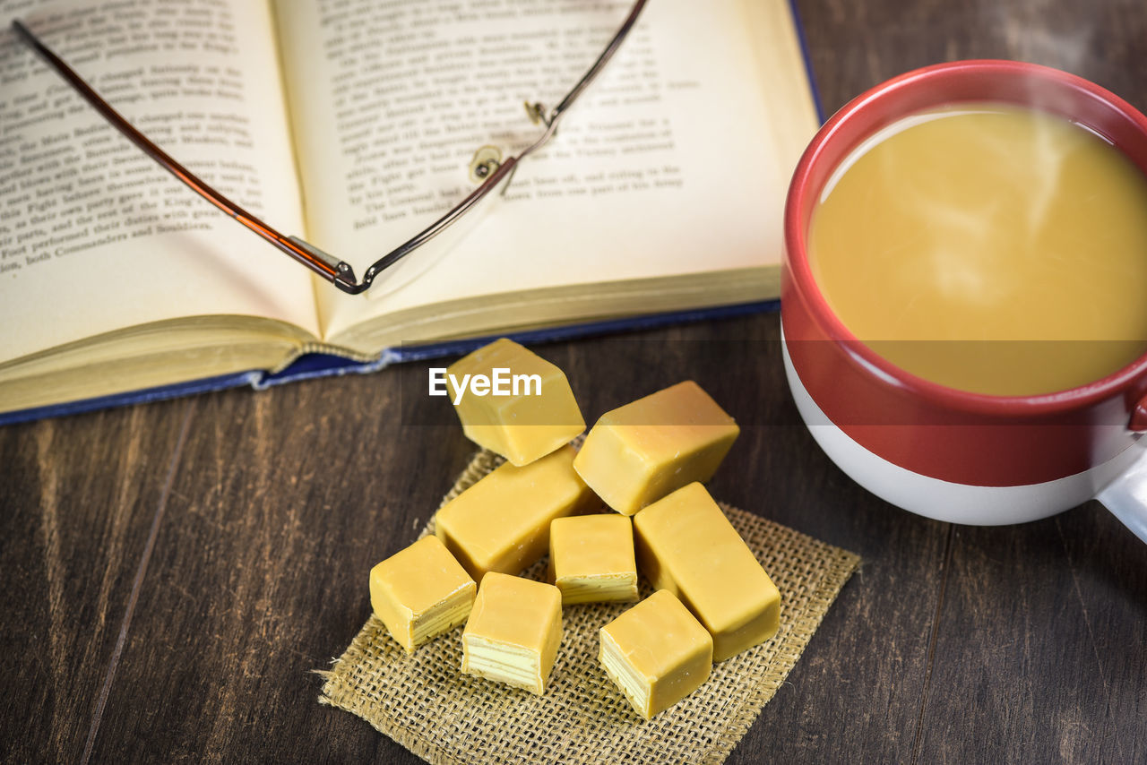 HIGH ANGLE VIEW OF YELLOW AND BOOKS ON TABLE