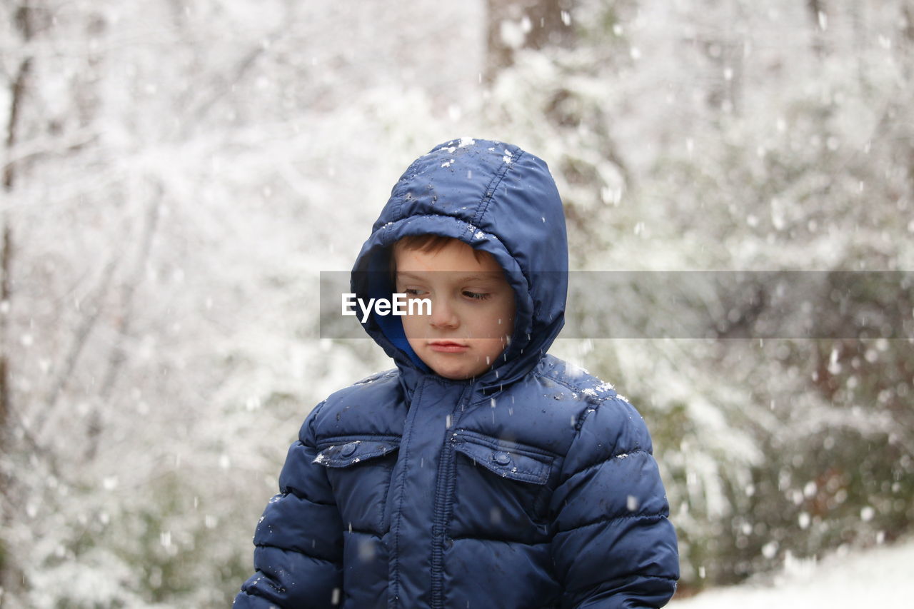 Cute boy wearing warm clothing during snowfall