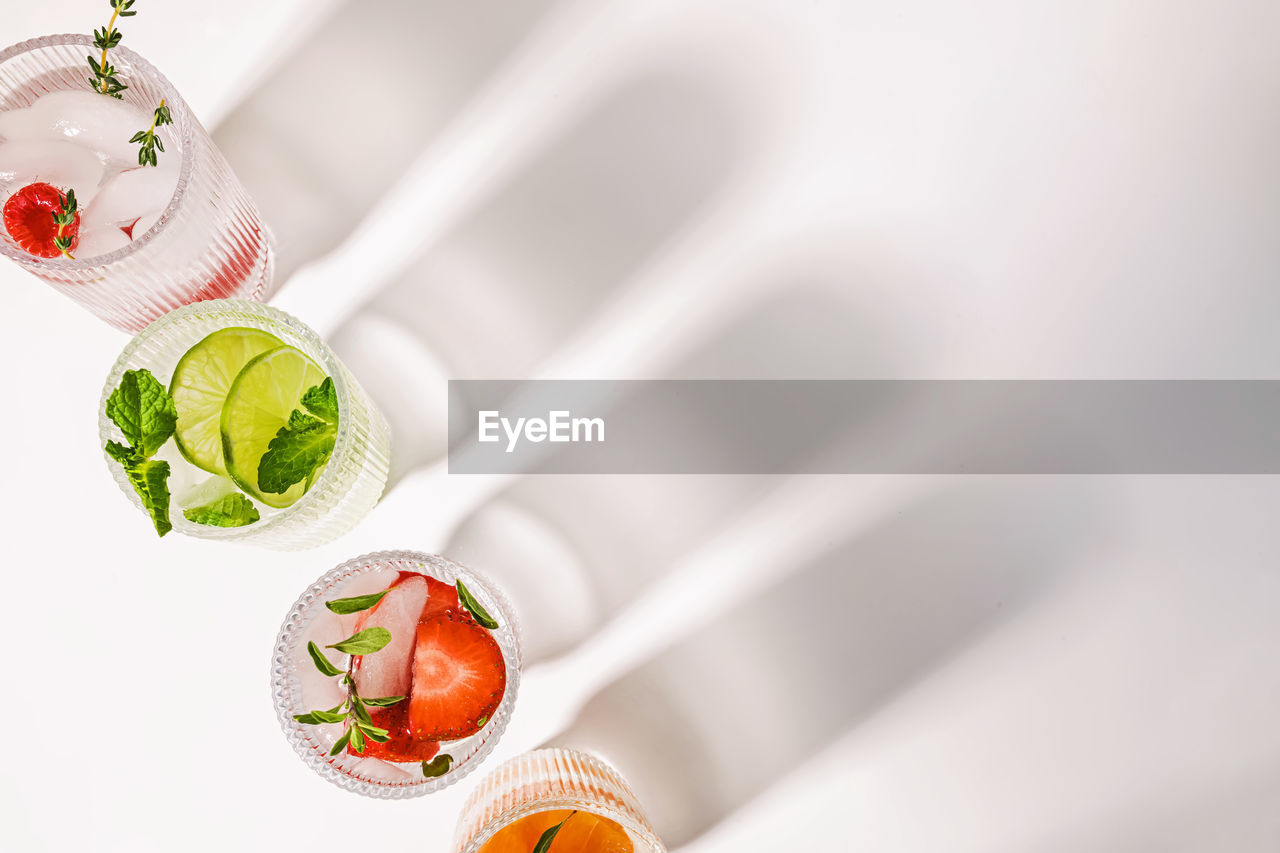 Infused waters with different flavors, summer refreshing drinks in a ribbed glasses, top view