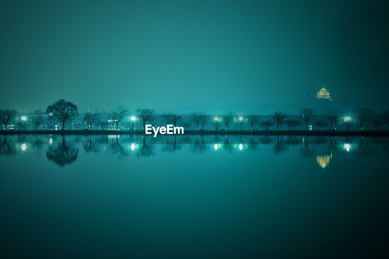 Scenic view of lake against sky at night