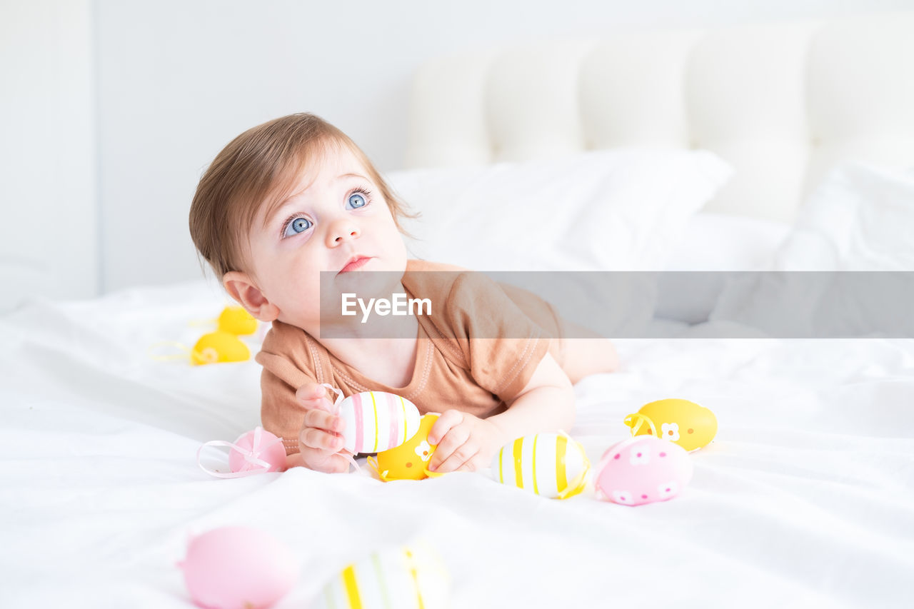 portrait of cute baby girl sleeping on bed at home
