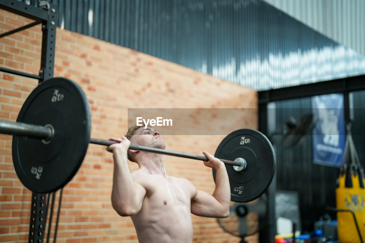 weight, exercising, muscular build, weight training, strength, sports training, sports, lifestyles, barbell, gym, vitality, athlete, wellbeing, adult, bodybuilding, sports equipment, cross training, picking up, determination, exercise equipment, heavy, overhead press, health club, young adult, human muscle, one person, men, motivation, sports clothing, equipment, indoors, strength training, activity, body care, bodypump, recreation, arm, concentration, fitness professional, dedication, room, dumbbell, clothing, holding, leisure activity, challenge, self improvement, incentive, relaxation, motion, body conscious, player, bodybuilder, copy space, conquering adversity, person, training class, women
