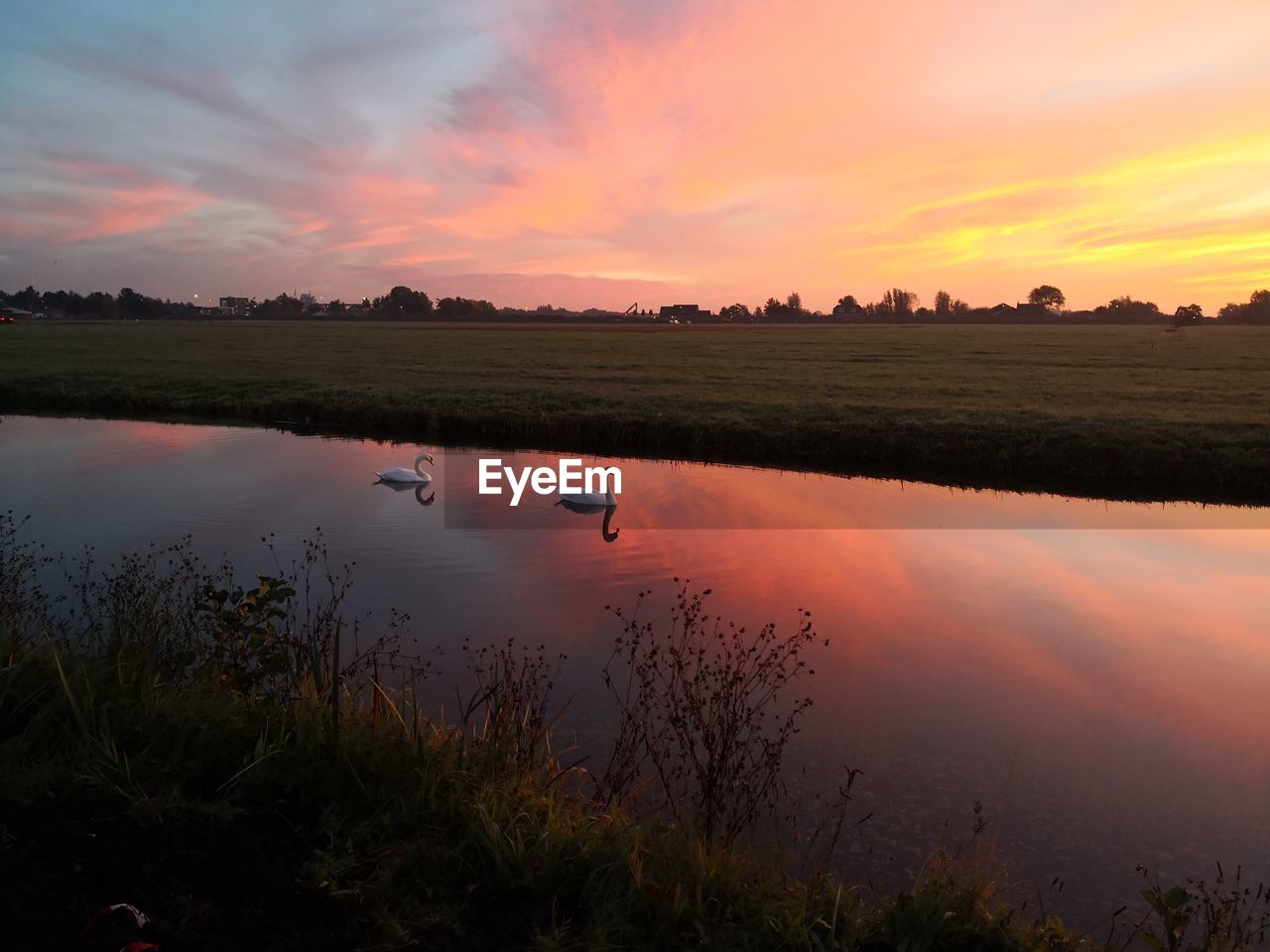 SCENIC VIEW OF LAKE AGAINST SKY AT SUNSET