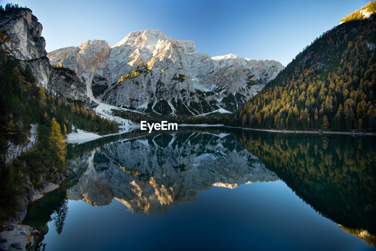 REFLECTION OF MOUNTAIN IN LAKE AGAINST SKY