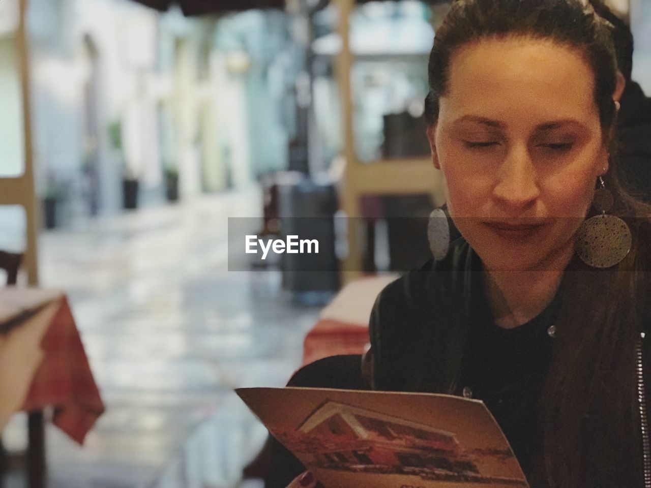 Woman looking at photograph in restaurant