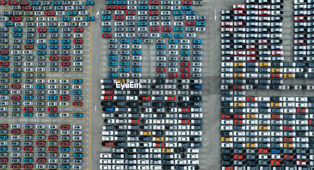 Aerial view of new cars stock at factory parking lot. above view cars parked in a row. automotive 