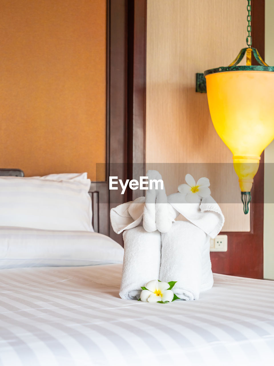 Flowers and towels on bed at hotel room