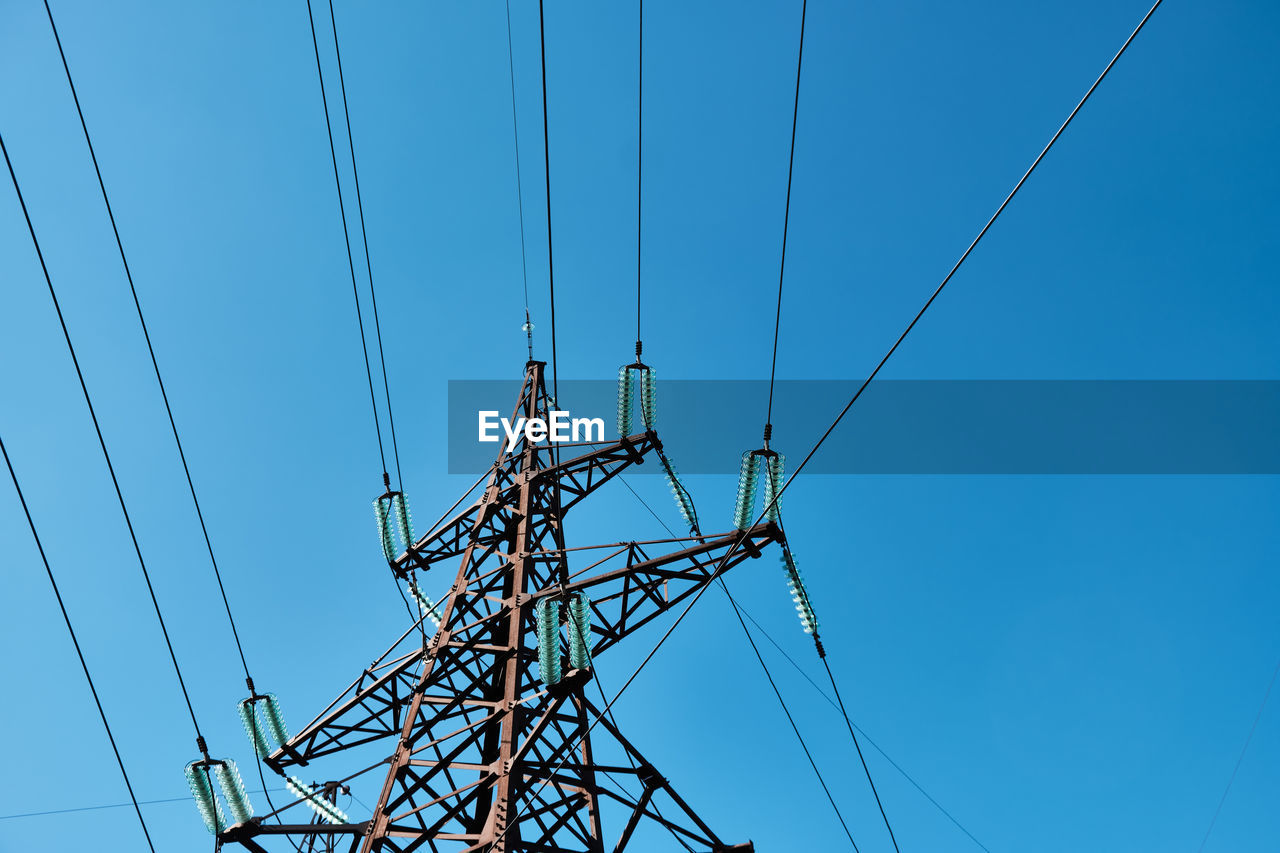 low angle view of electricity pylon against blue sky