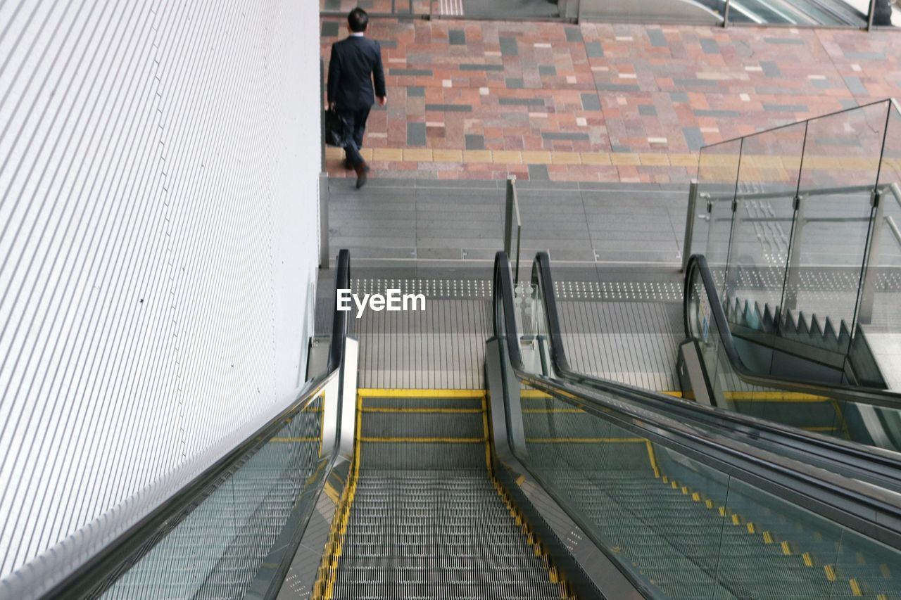 High angle view of man walking on staircase at railroad station