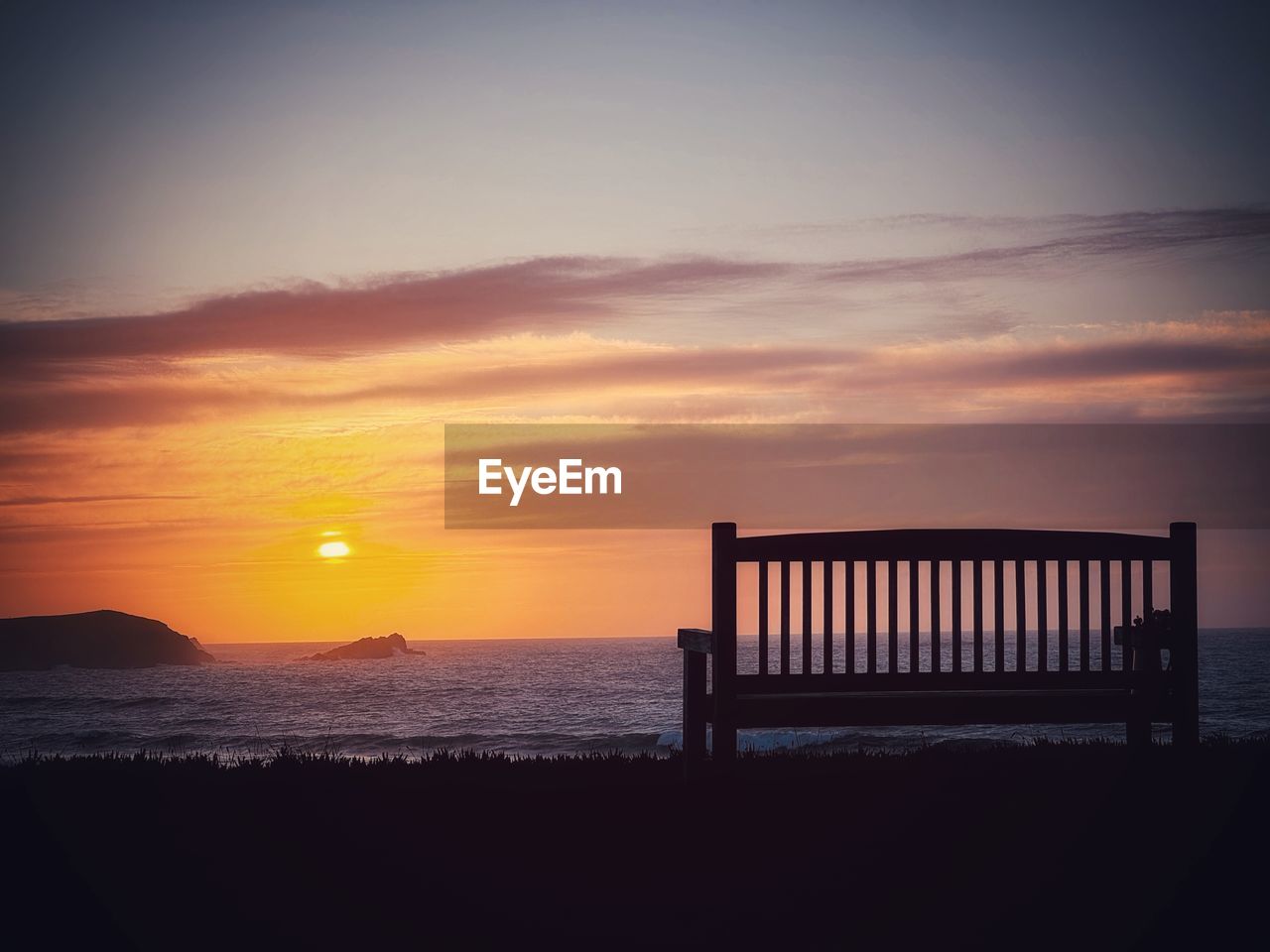 sky, sunset, sea, water, horizon, beauty in nature, scenics - nature, nature, tranquility, beach, tranquil scene, land, cloud, dawn, sunlight, ocean, horizon over water, evening, orange color, silhouette, idyllic, sun, no people, dramatic sky, afterglow, outdoors, travel destinations, relaxation, coast, seascape, vacation, holiday, trip, architecture, landscape, environment, wood, seat, summer