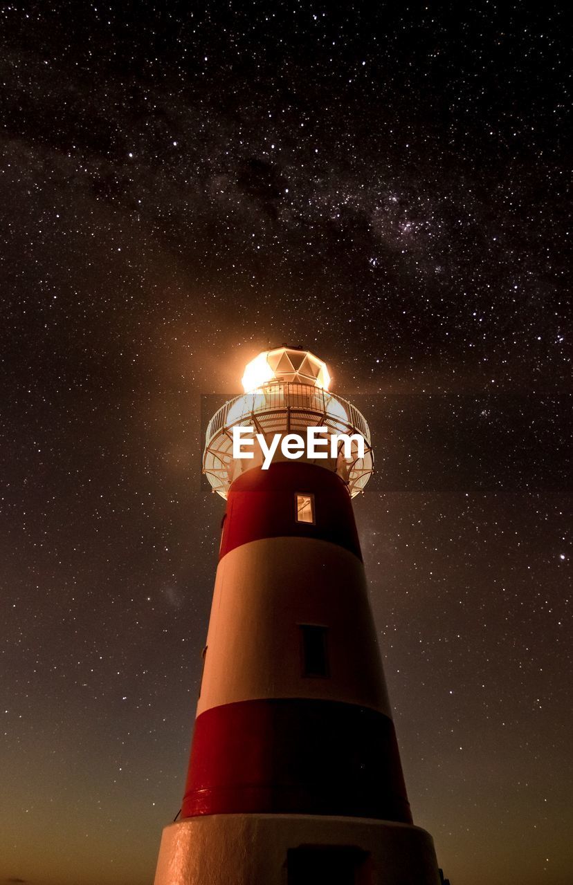 LOW ANGLE VIEW OF ILLUMINATED BUILDING AGAINST SKY AT NIGHT