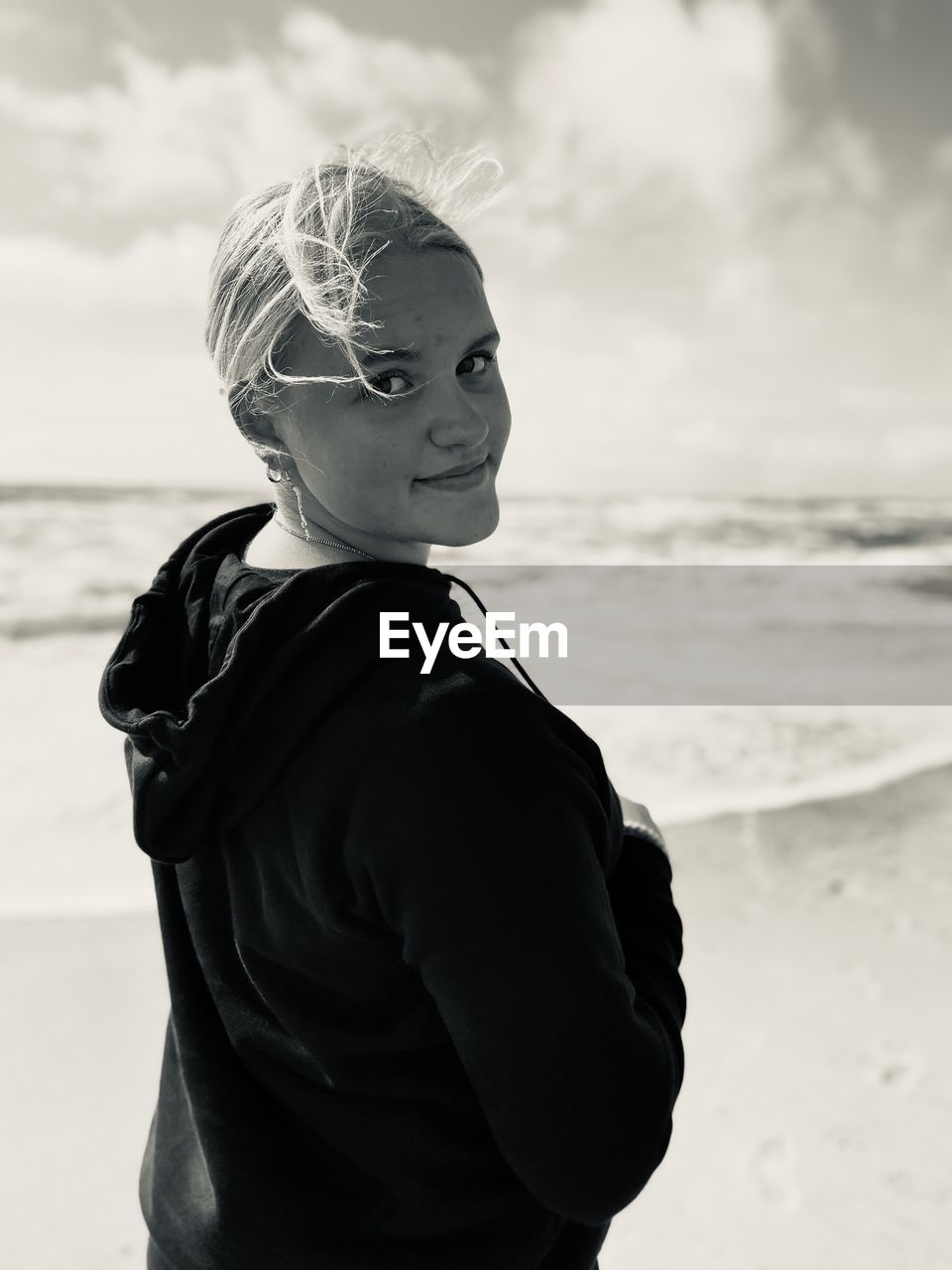 Girl standing at beach against sky