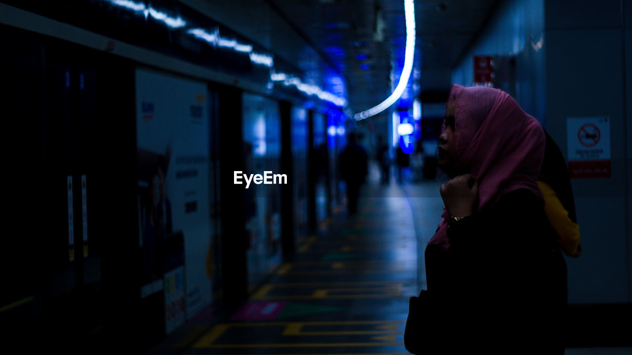 Rear view of woman walking in tunnel jakarta mrt