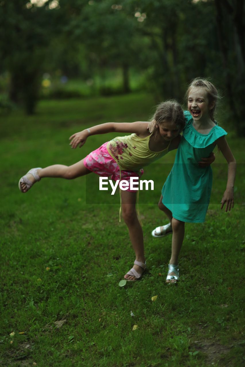 Happy sisters playing on field