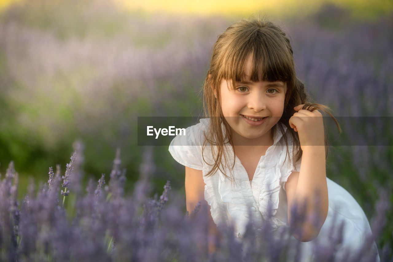 PORTRAIT OF A SMILING GIRL WITH PURPLE EYES