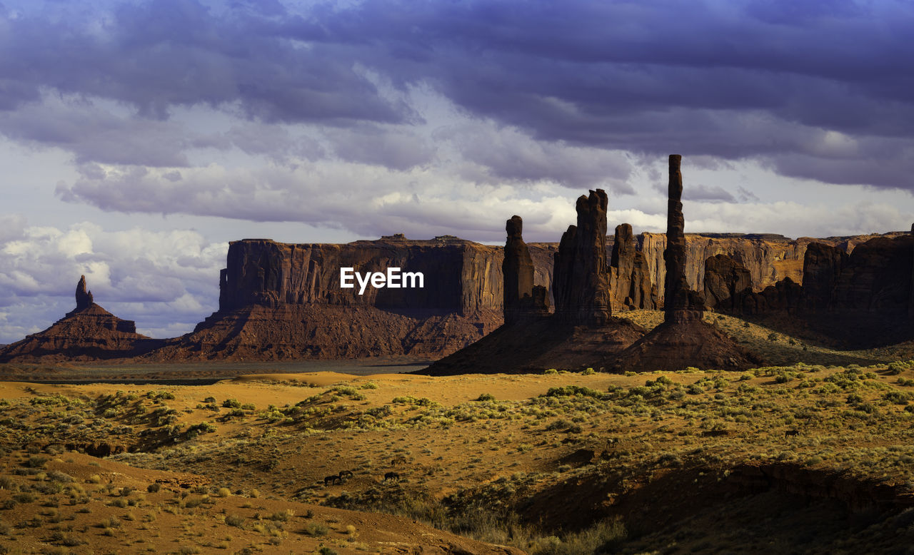 ROCK FORMATIONS ON LANDSCAPE AGAINST CLOUDY SKY