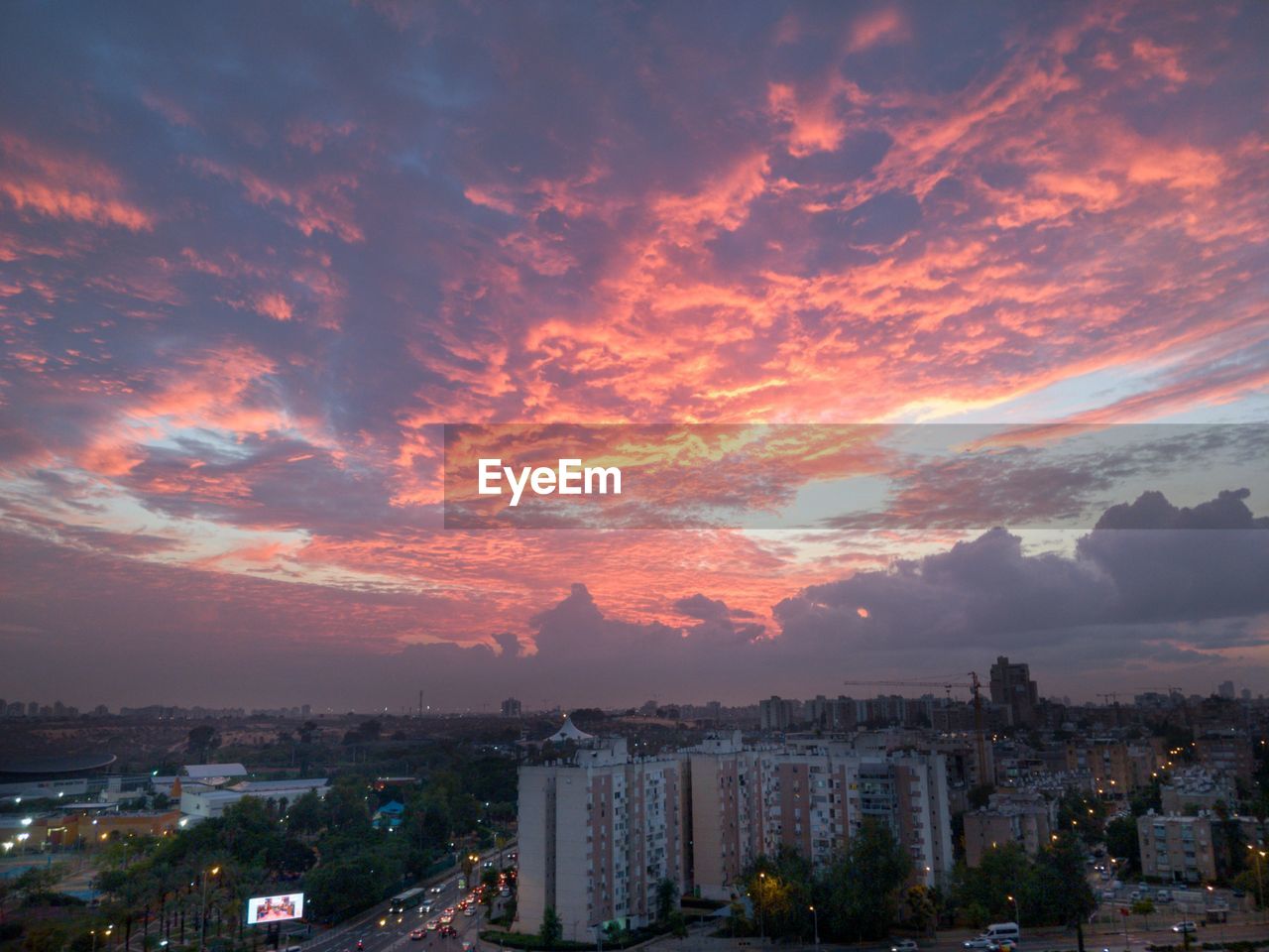 HIGH ANGLE SHOT OF TOWNSCAPE AGAINST SKY AT SUNSET