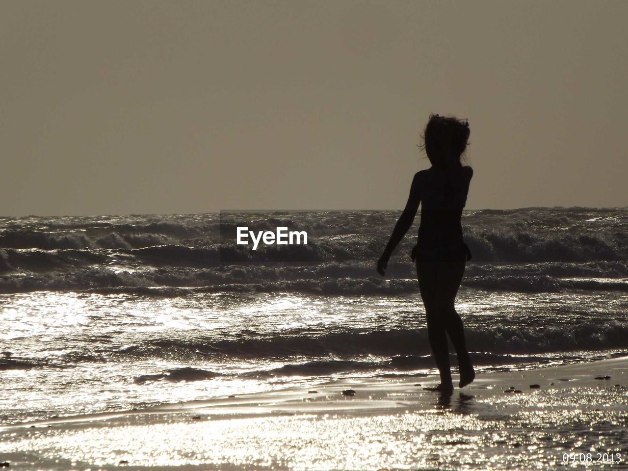 Silhouette of girl walking on beach