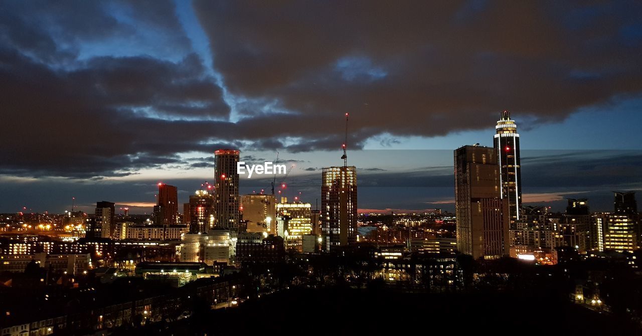 ILLUMINATED CITYSCAPE AGAINST SKY