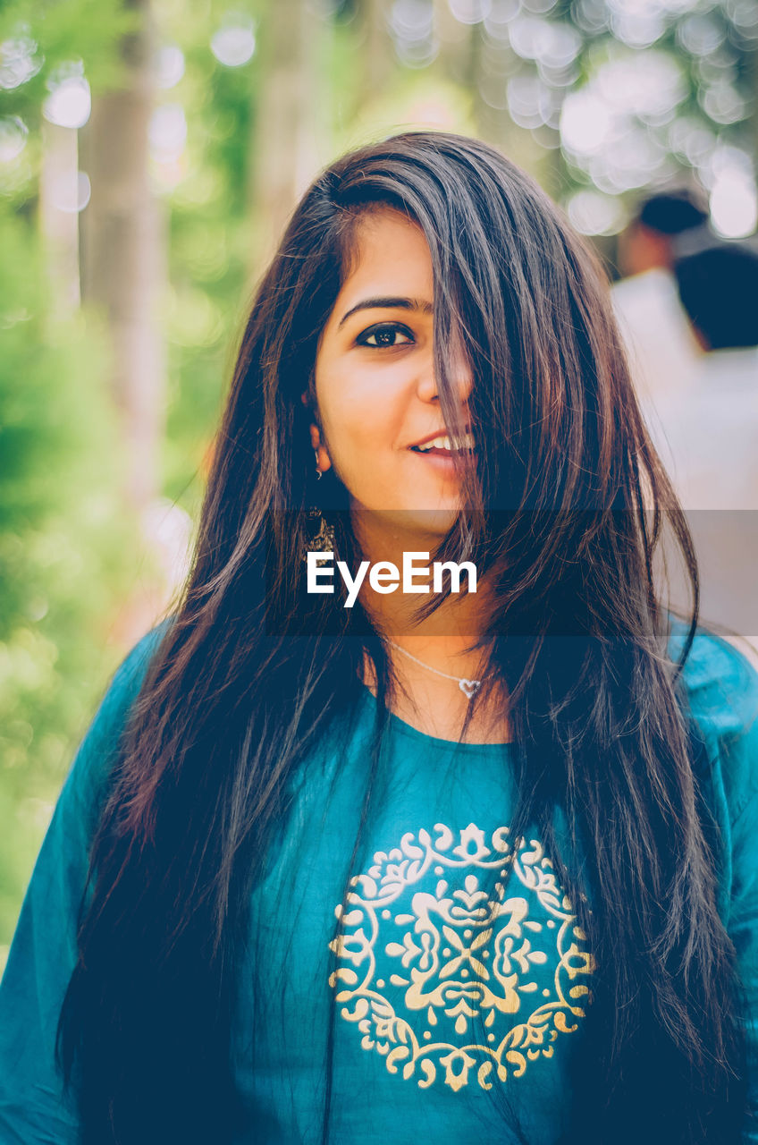 Portrait of smiling beautiful woman standing outdoors