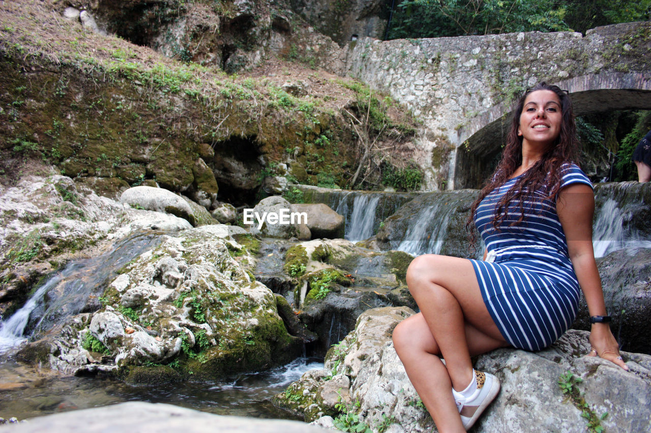 WOMAN SITTING ON ROCK