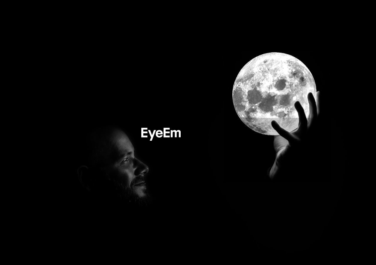 Digital composite image of man holding moon