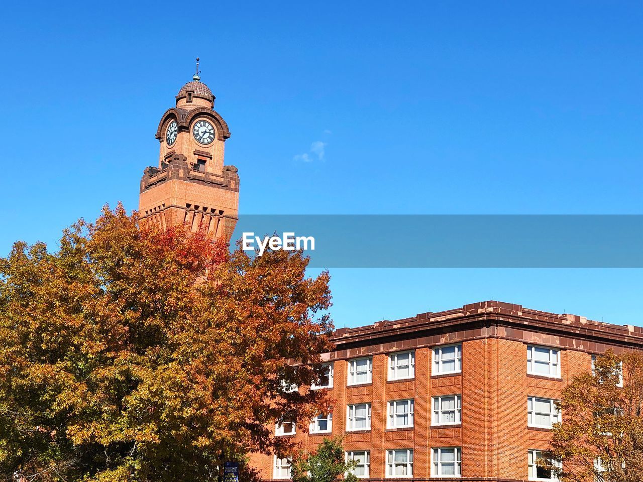 LOW ANGLE VIEW OF CLOCK TOWER AGAINST BUILDING