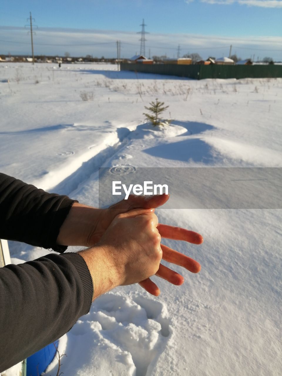hand, winter, snow, cold temperature, nature, one person, sky, day, land, sunlight, environment, ice, water, frozen, freezing, outdoors, leisure activity, adult, personal perspective, men, beauty in nature