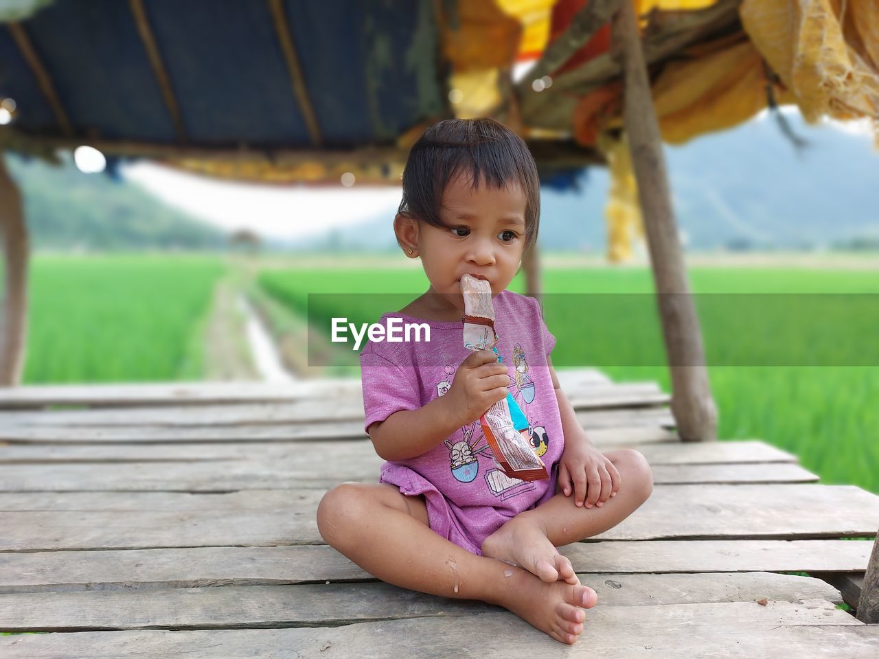 Daughter eats ice cream in the fields