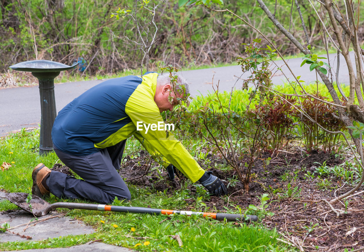 SIDE VIEW OF MAN WORKING IN FIELD